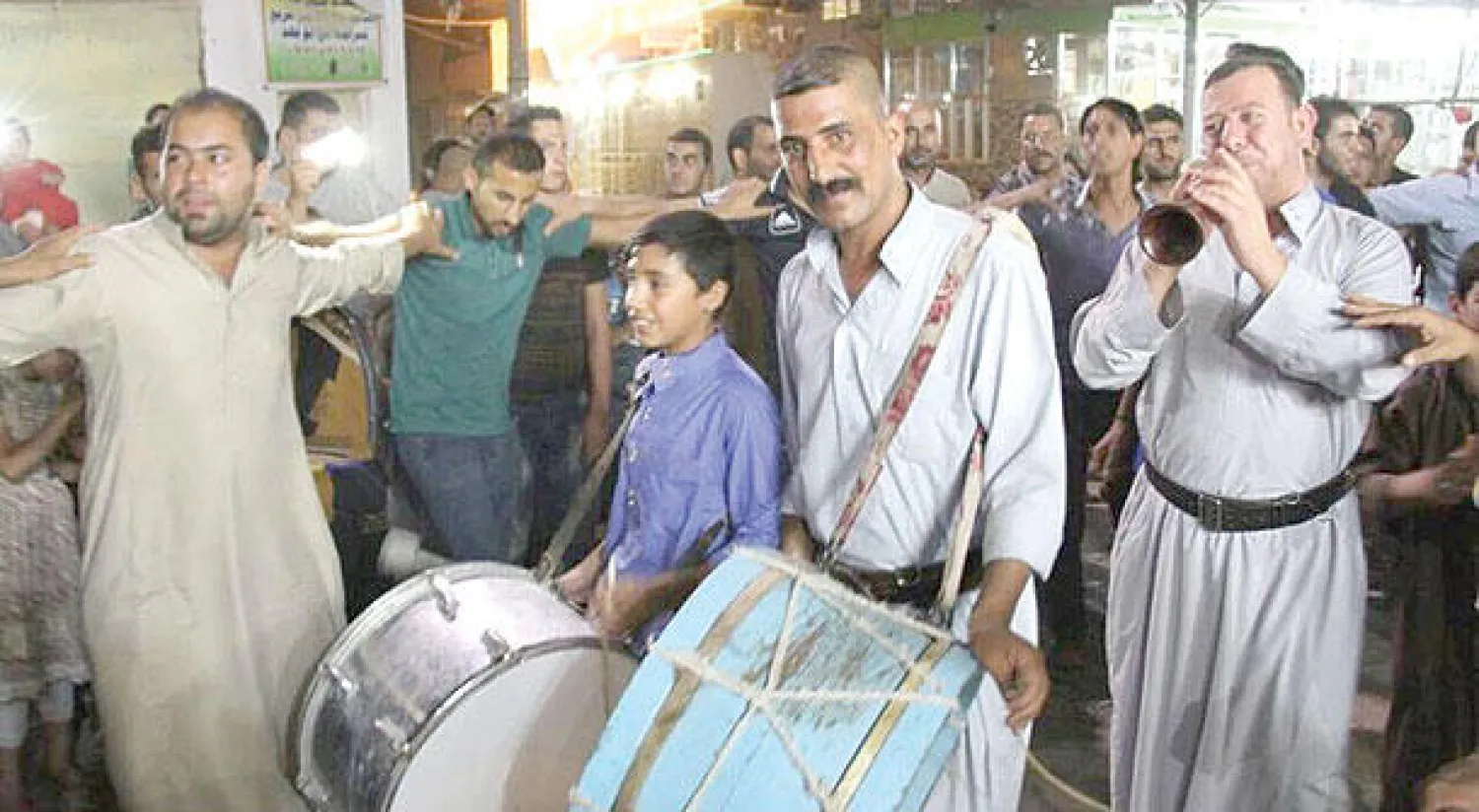 المسحراتي أبو محمد وأعضاء فريقه بين أهالي مدينة بعقوبة وهم يؤدون  رقصة الدبكة الشعبية احتفالاً بالشهر الكريم في ساعات متأخرة من الليل