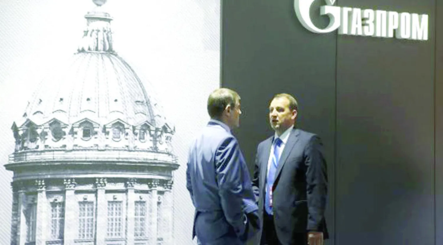 رجلان بالقرب من جناح شركة غازبروم في منتدى سان بطرسبرغ الاقتصادي الدولي (رويترز)