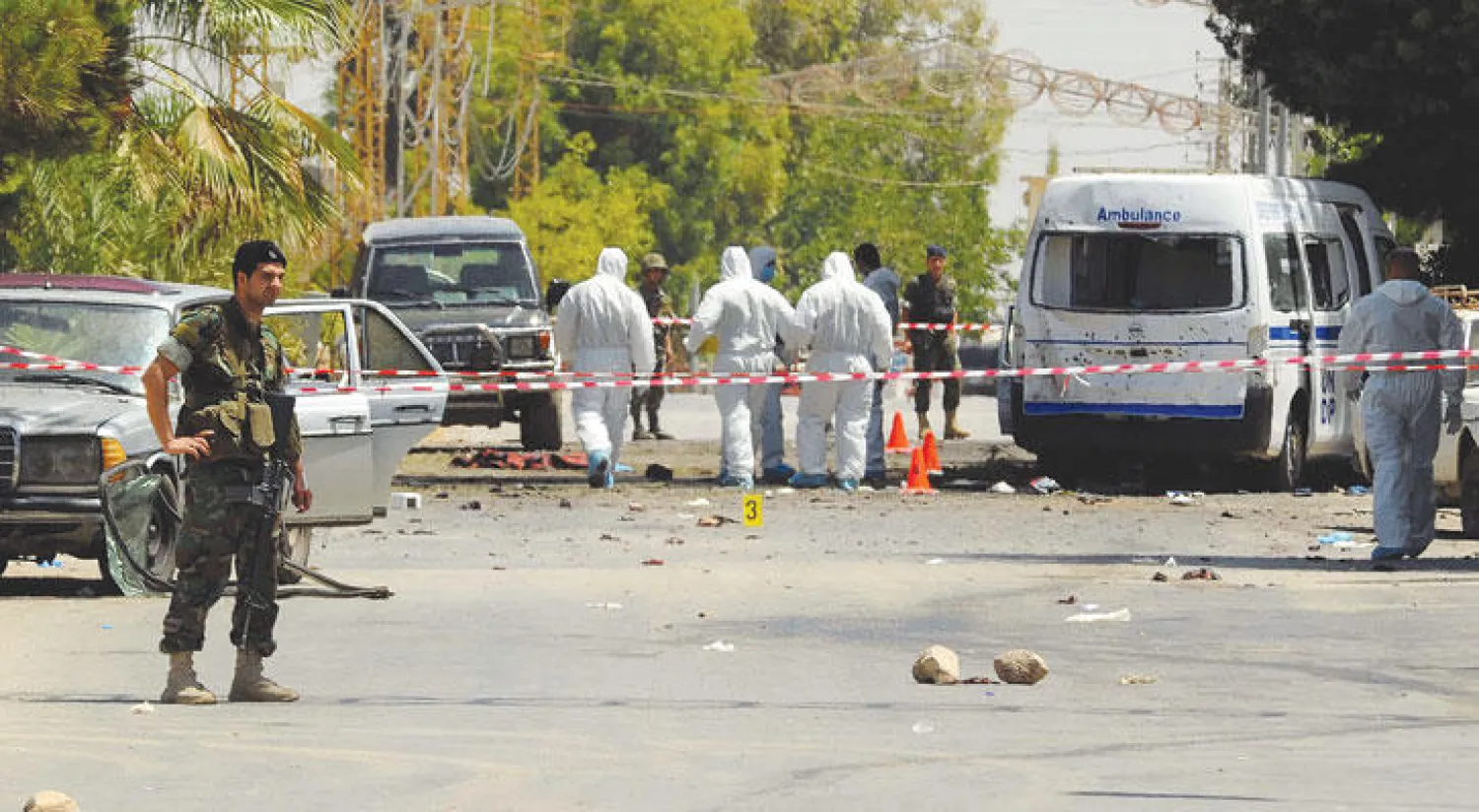 عناصر من الجيش اللبناني ومفتشي الطب الشرعي يعاينون موقع الهجمات الانتحارية في بلدة القاع اللبنانية على الحدود مع سوريا أمس (رويترز)