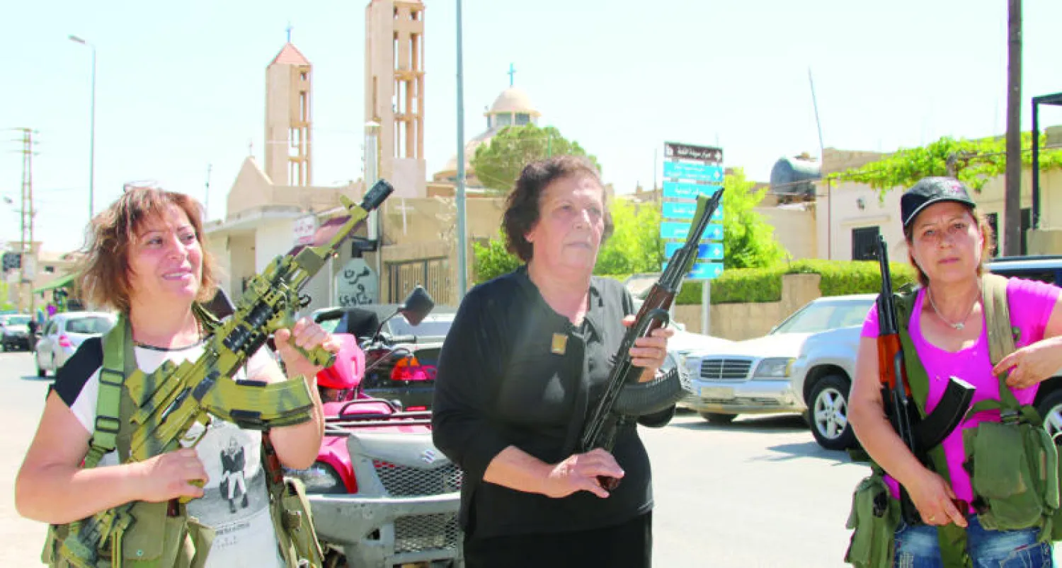 نساء لبنانيات من قرية القاع المسيحية حملن السلاح أمس بعد الانفجارات التي هزت قريتهم قرب الحدود اللبنانية السورية (أ.ف.ب)