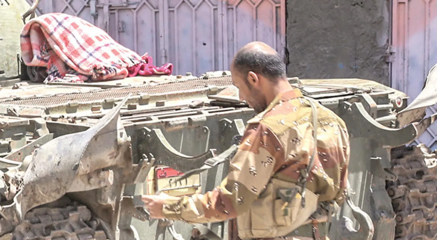 أحد أفراد القوات الشرعية أمام دبابته عند مدخل مدينة تعز (أ.ف.ب)