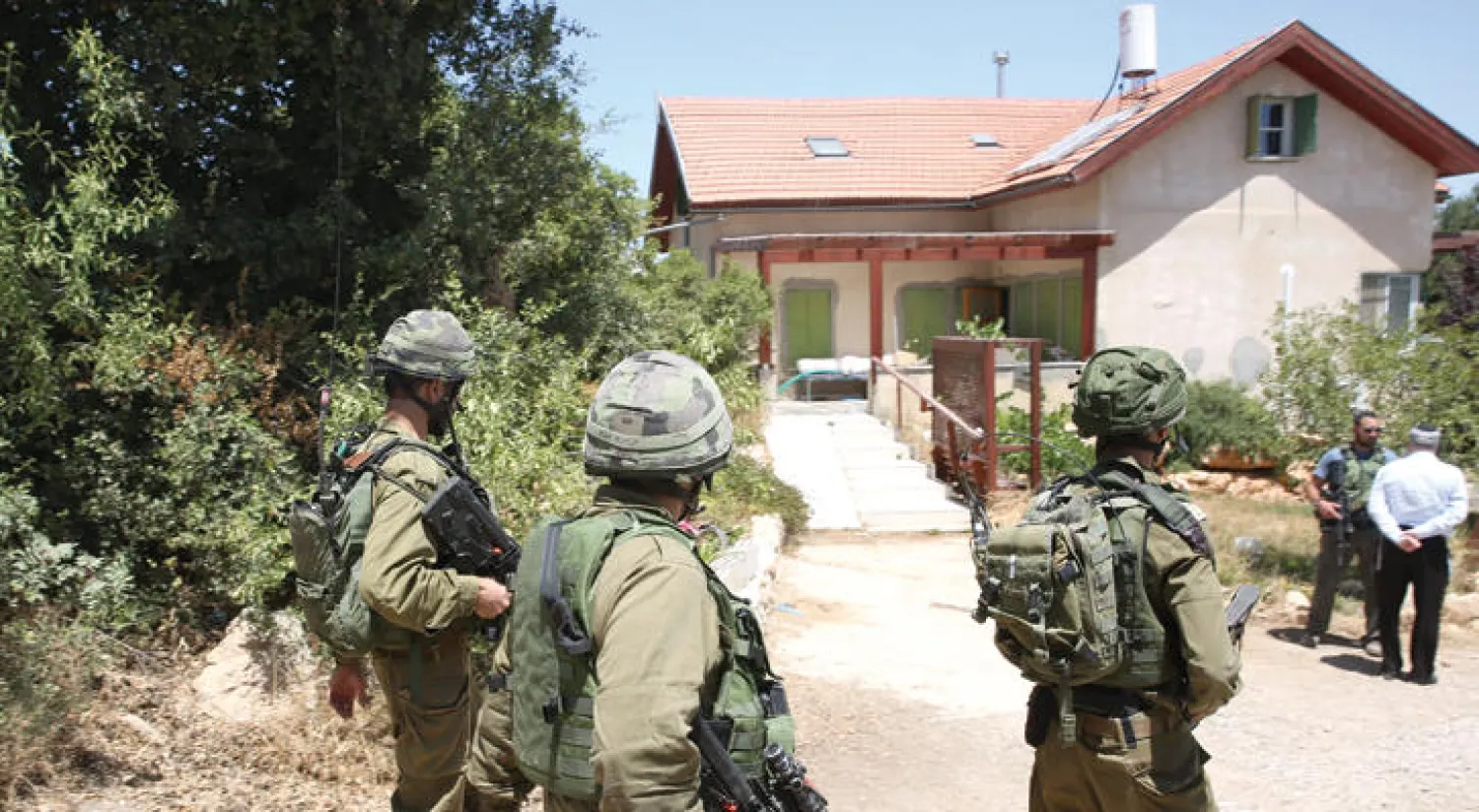 جنود إسرائيليون بالقرب من المنزل الذي قتلت فيه الطفلة الإسرائيلية من طرف شاب فلسطيني أمس (أ.ف.ب)