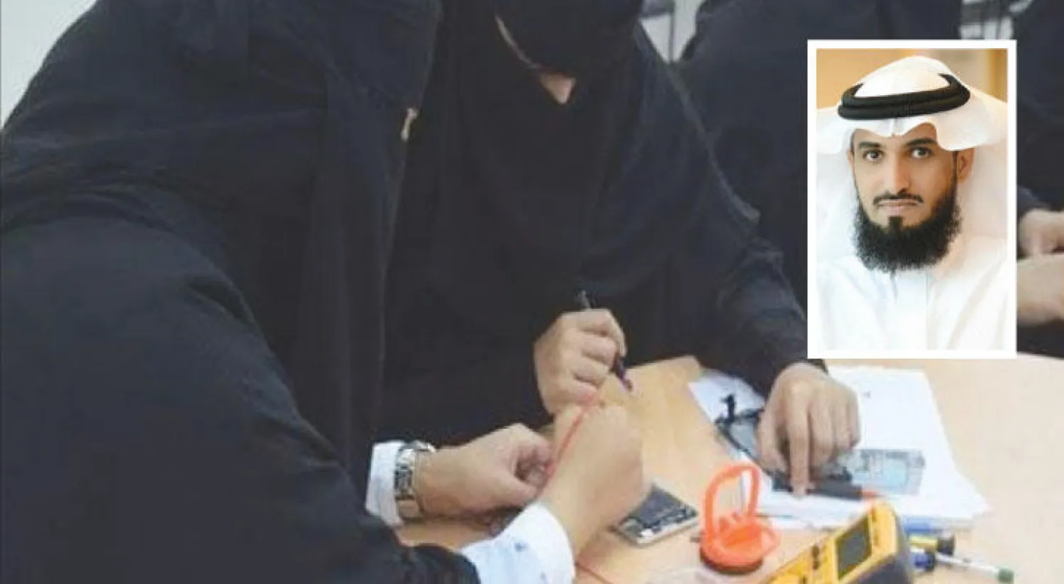 سعوديات في أثناء محاولتهن إصلاح الجوالات.. وفي الاطار خالد أبا الخيل المتحدث الرسمي باسم وزارة العمل والتنمية الاجتماعية السعودية