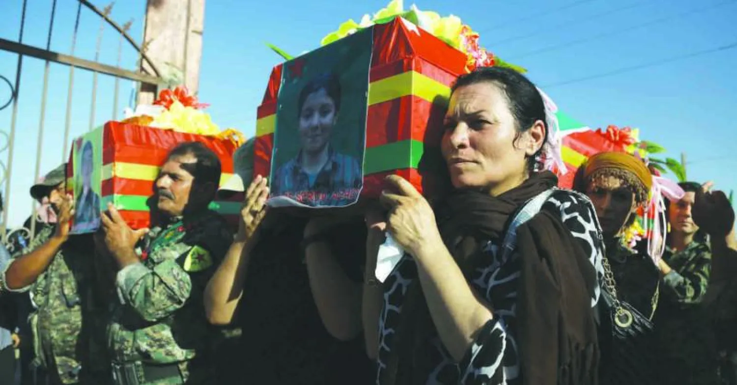 كرديات يحملن جثمان مقاتلة في مدينة القامشلي شمال سوريا في جنازة أول من أمس لمقاتلين من قوات سوريا الديمقراطية قتلوا في معركة منبج ضد تنظيم داعش (أ.ف.ب)