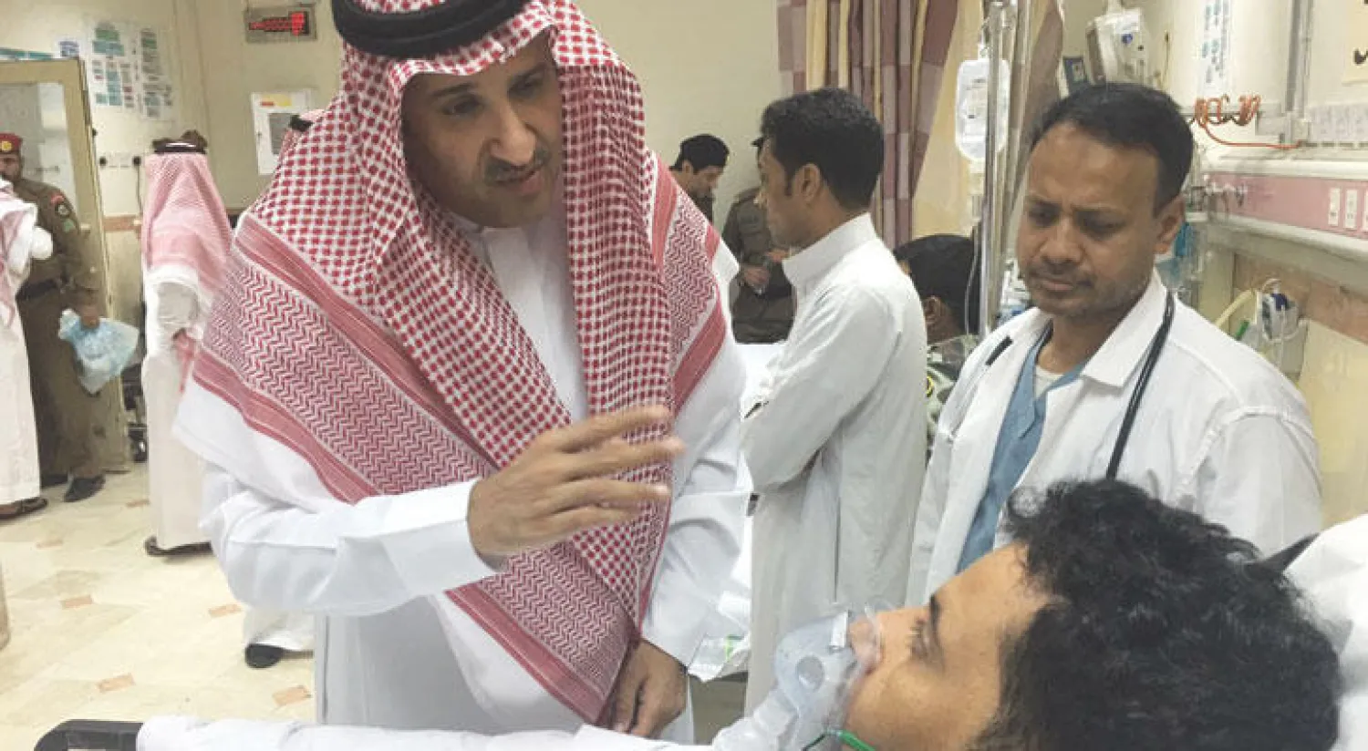 الأمير فيصل بن سلمان لدى زيارته أحد المصابين في المدينة المنورة أمس («الشرق الأوسط»)