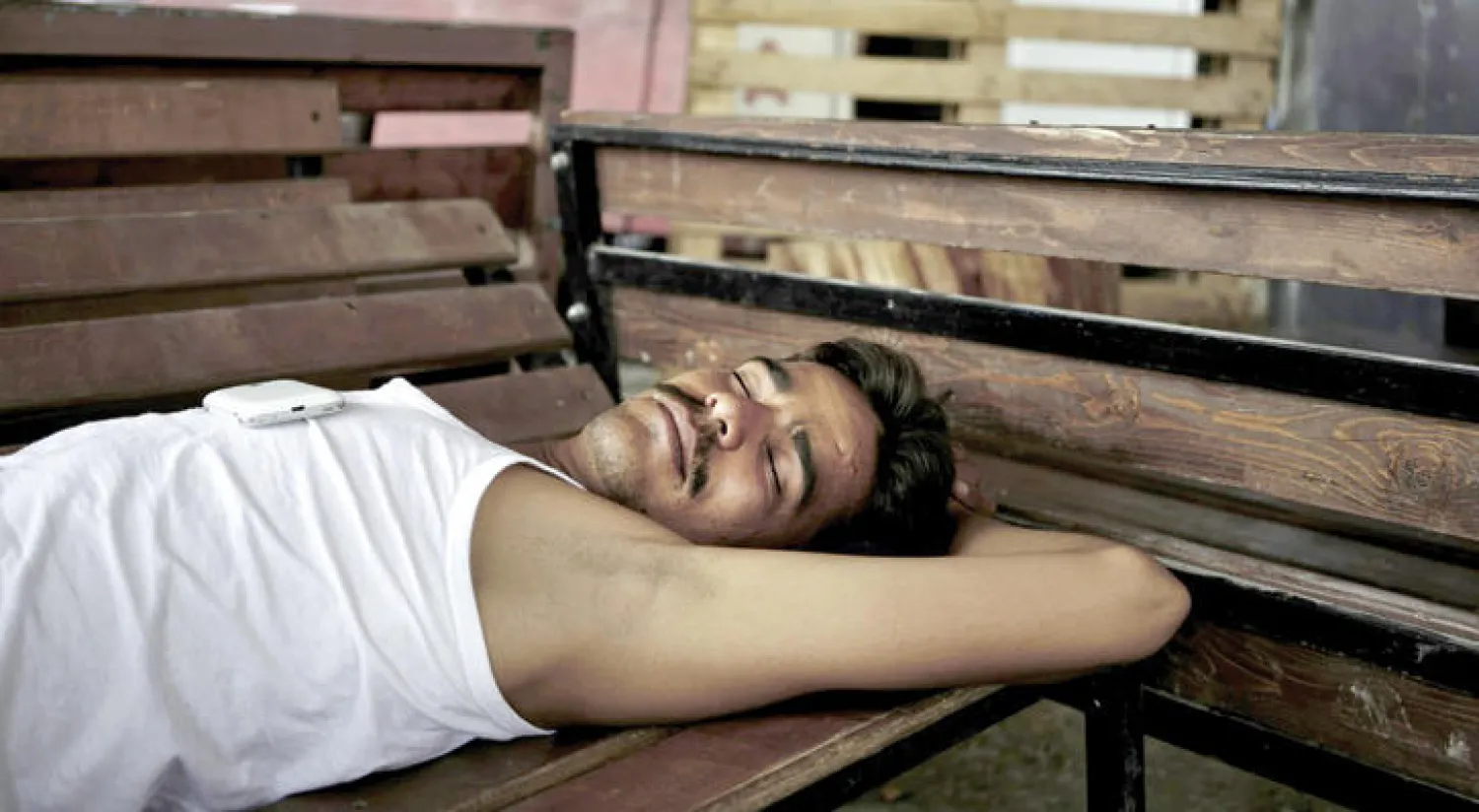 مهاجر مستلقٍ خارج مخيم «موريا» في جزيرة ليسبوس اليونانية في 19 يونيو الماضي (أ.ف.ب)