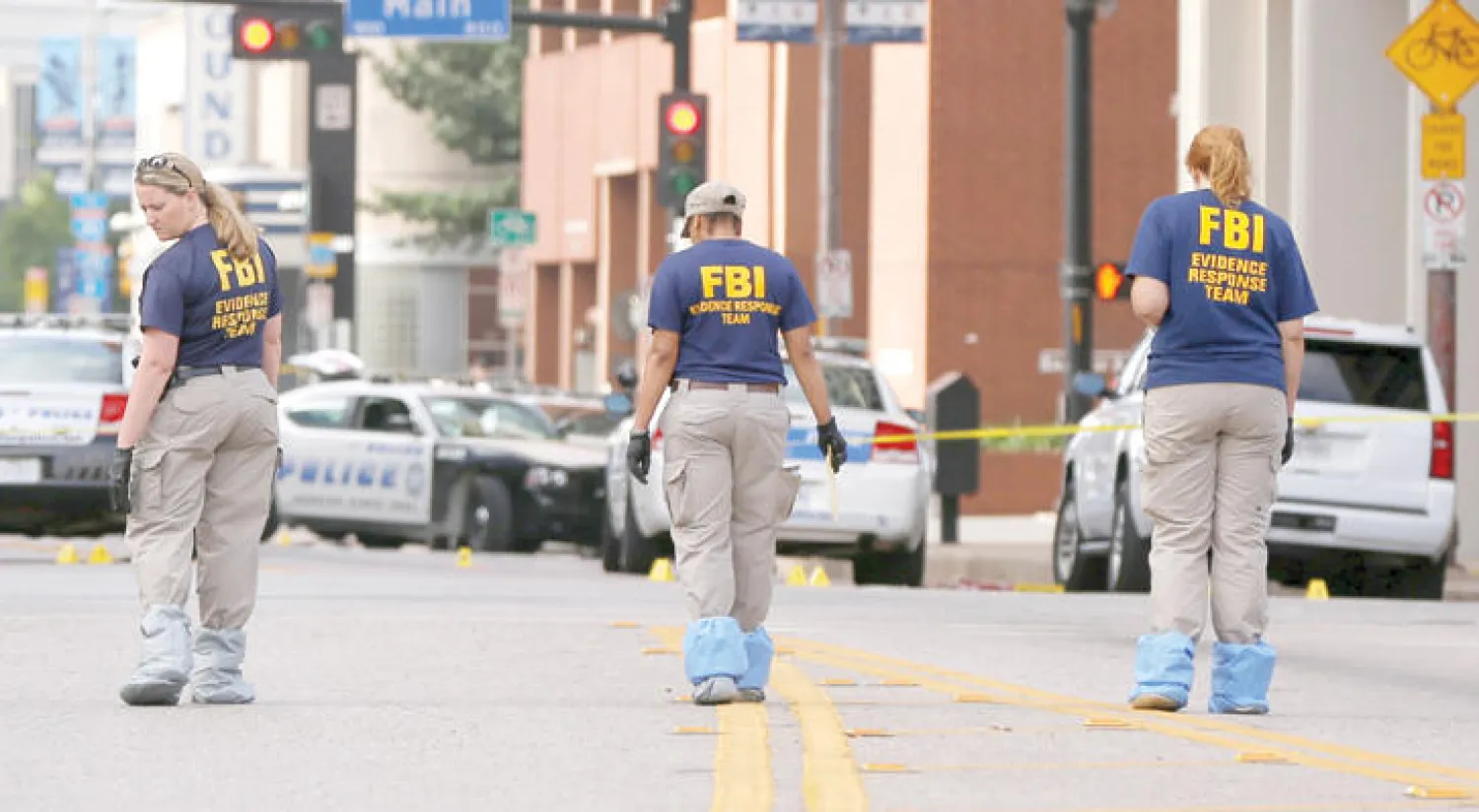 عناصر المباحث الأميركية يبحثون عن أدلة جنائية في شوارع دالاس أمس (رويترز)