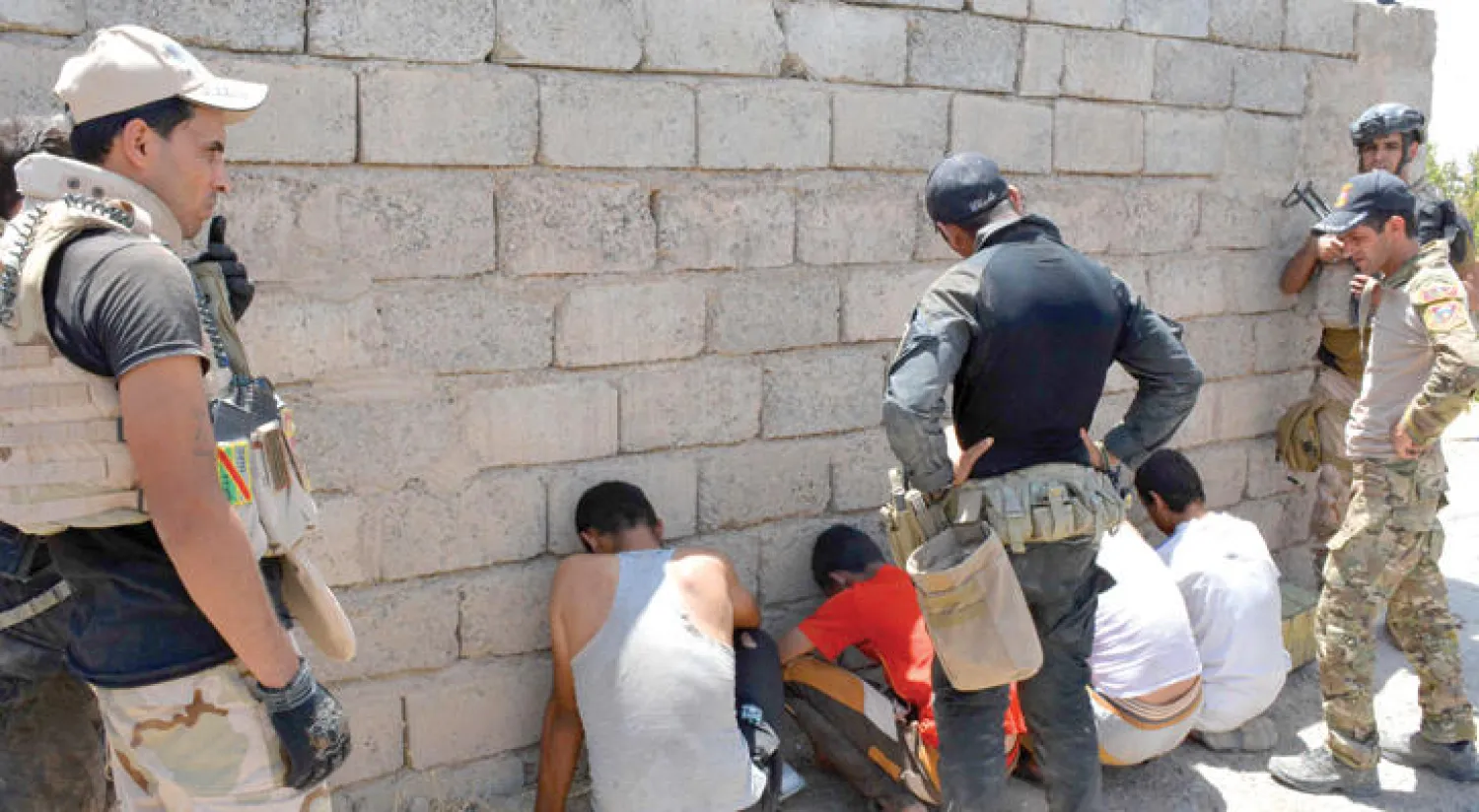 دورية أمنية تحقق مع مواطنين جرى إيقافهم بالقرب من قاعدة عسكرية بضواحي الموصل (أ.ف.ب)