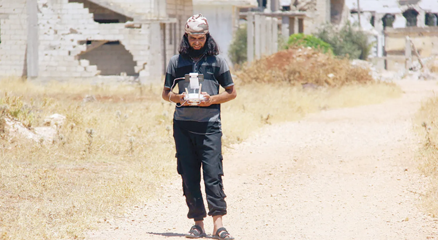 مقاتل يجرب طائرة من دون طيار (درون) صغيرة في إحدى المناطق القليلة الخاضعة لسيطرة المعارضة السورية في حمص أمس (أ.ف.ب)