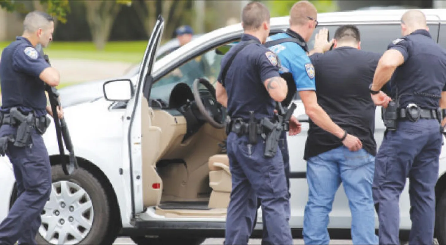 عناصر من الشرطة تتفقد مشتبهًا بعد الحادثة في مدينة باتون روج التابعة لولاية لويزيانا أمس (رويترز)