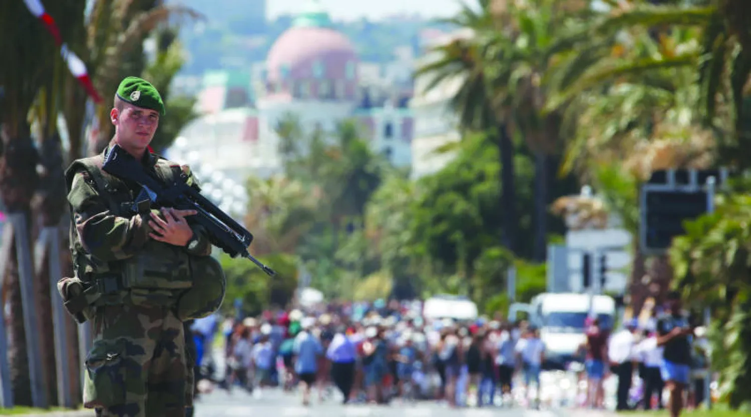 أحد عناصر الأمن بكامل سلاحه في نيس عقب الاعتداء الإرهابي (رويترز)