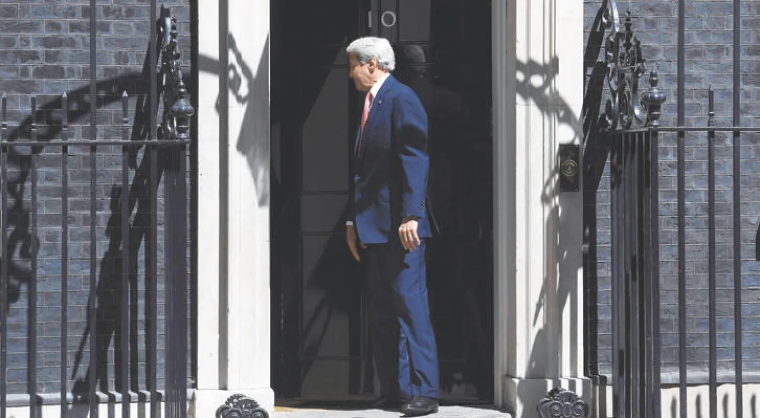 جون كيري محاولا الدخول إلى رقم 10 داونينغ ستريت (رويترز)