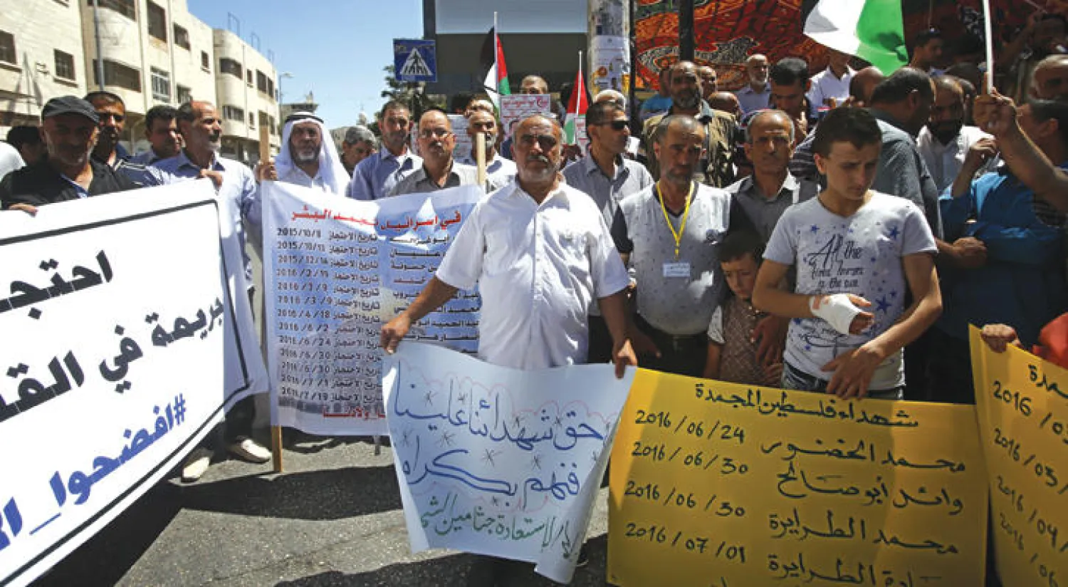 فلسطينيون يرفعون لافتات في شوارع الضفة الغربية مؤيدة للسجناء  بلال قايد ومحمد ومحمود بلبول الذين دخلوا إضرابا مفتوحا عن الطعام (إ.ب.أ)