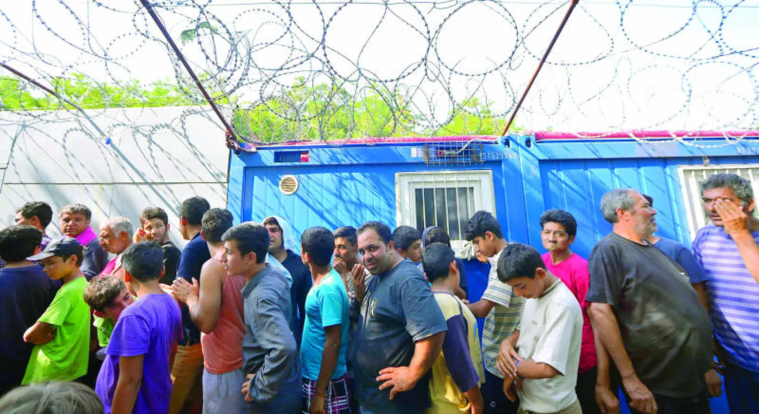 مهاجرون ولاجئون يصطفون في مخيم عند الحدود الصربية - المجرية أول من أمس (إ.ب.أ)