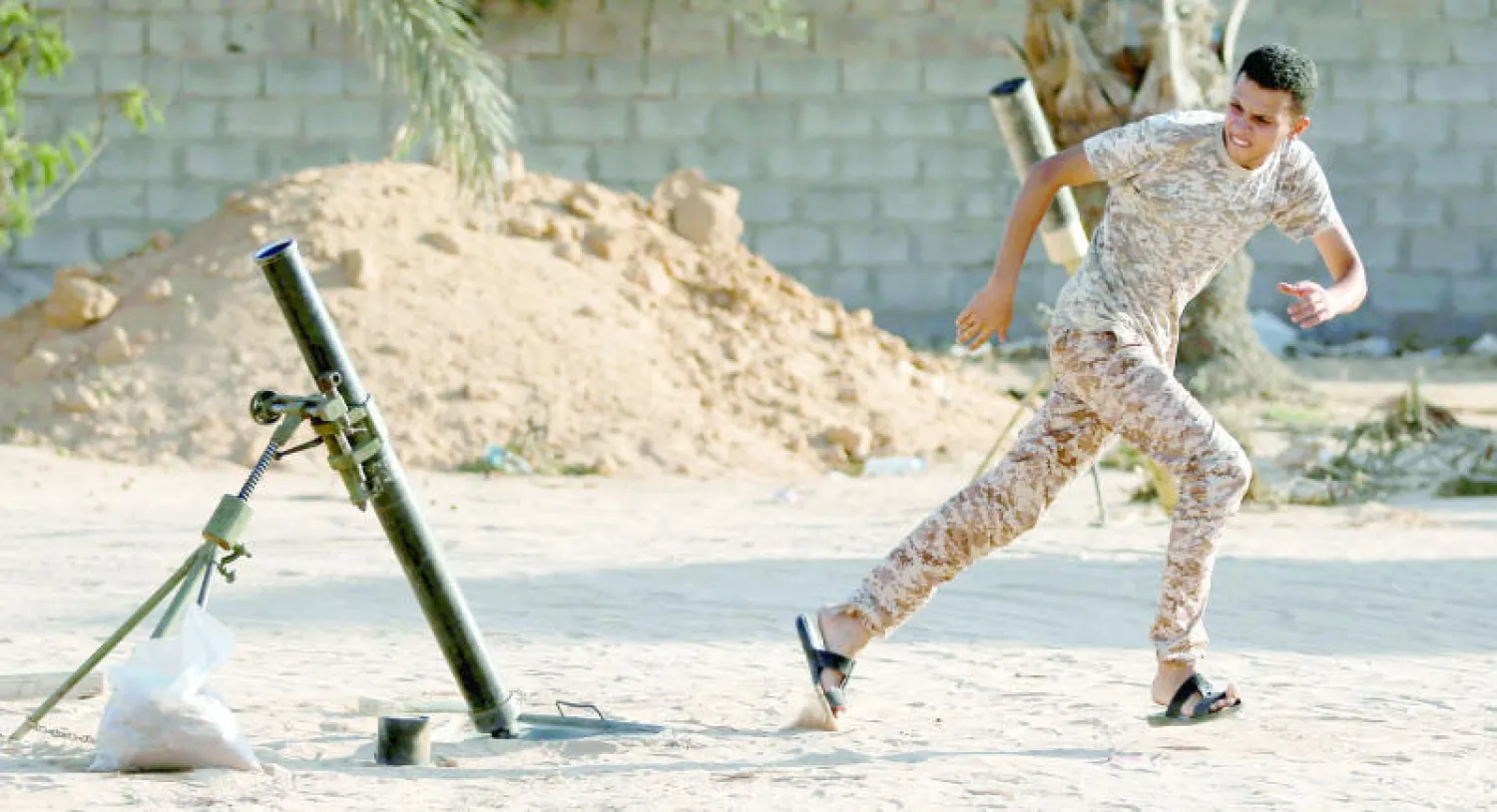 مقاتل من القوات الليبية الموالية لحكومة الوفاق يبعد عن منصة إطلاق صاروخ باتجاه داعش في مدينة سرات أمس (رويترز)