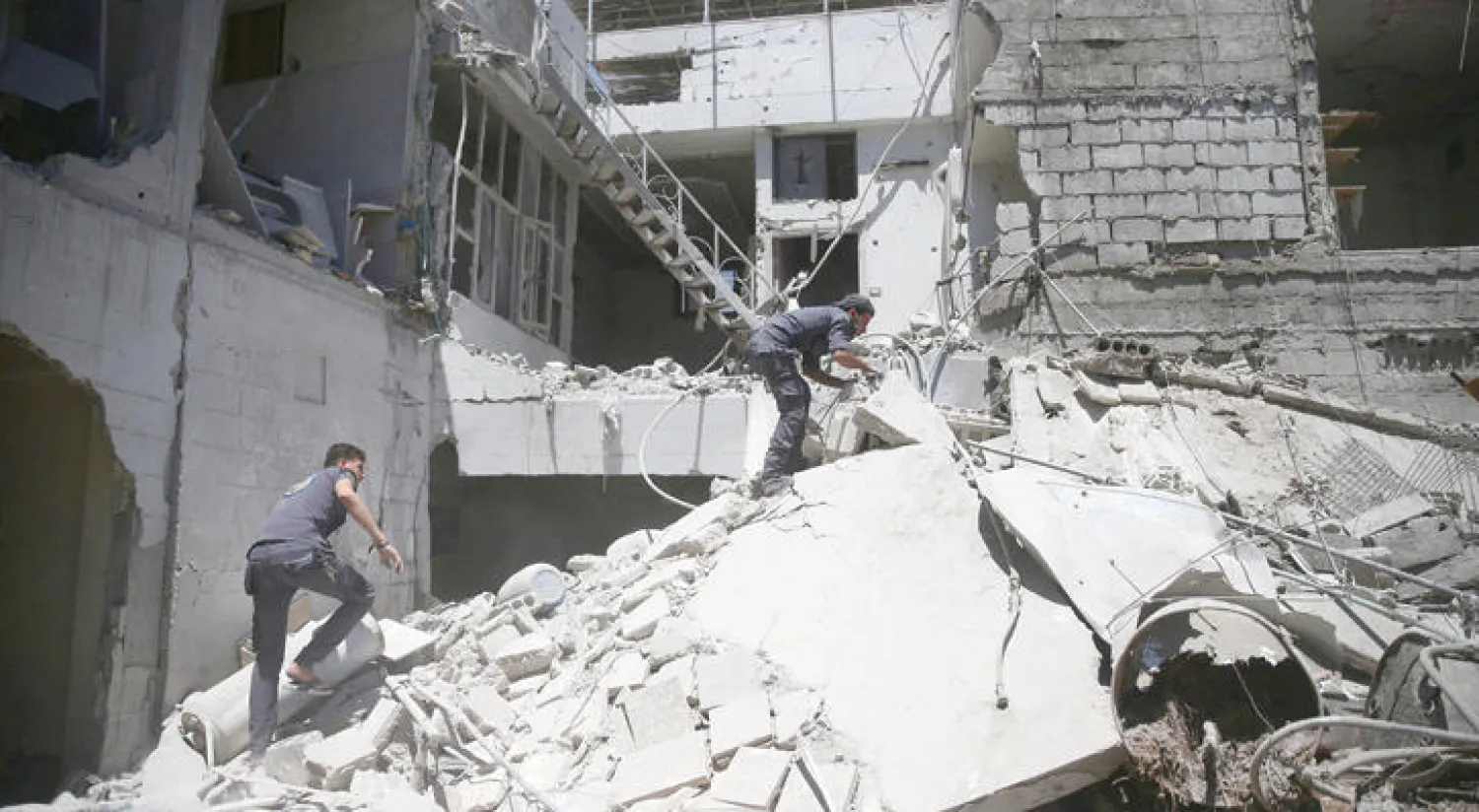 قوات الدفاع المدني تتفحص الدمار الذي لحق بحي في بلدة دوما قرب دمشق إثر غارة لطيران النظام أمس (رويترز)