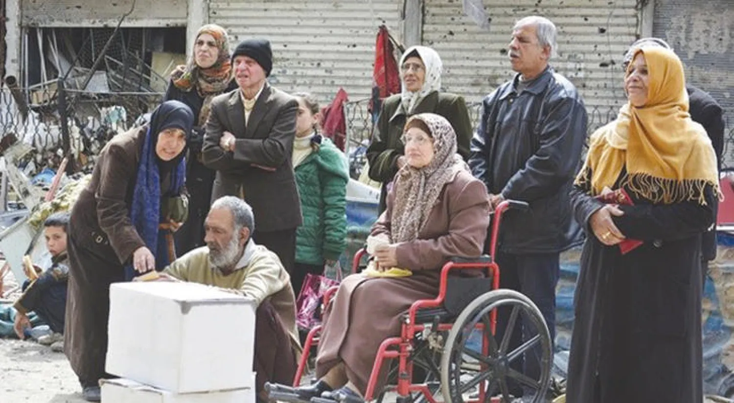 صورة أرشيفية لمدنيين في مخيم اليرموك ينتظرون الحصول على مساعدات غذائية (رويترز)