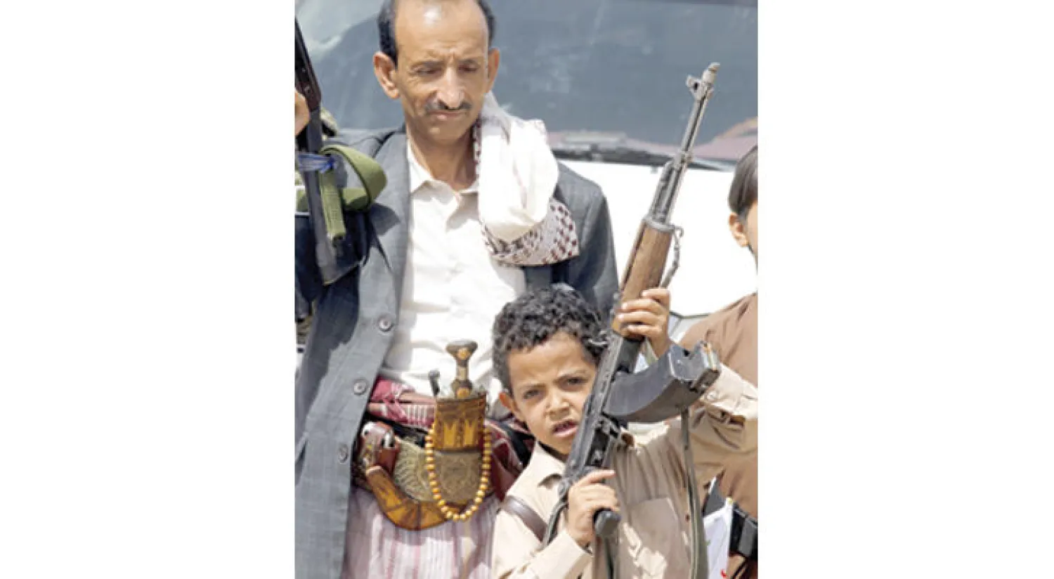 طفل يمسك بسلاح في استعراض حوثي قرب العاصمة صنعاء الشهر الماضي (إ.ب.أ)