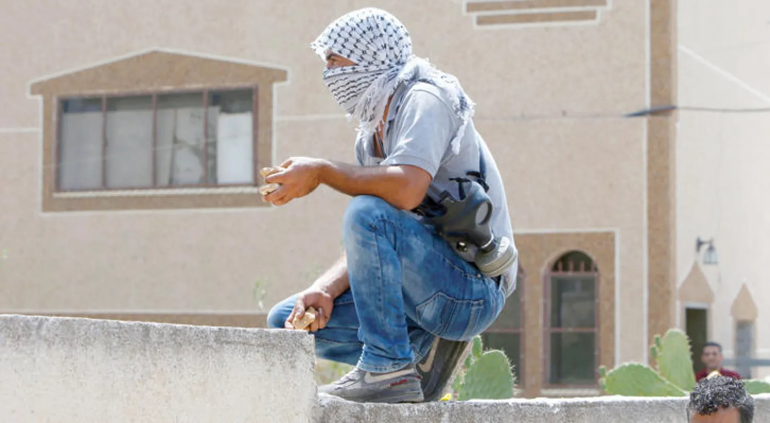 شاب فلسطيني يحمل في يده حجارة خلال مواجهات مع الشرطة الإسرائيلية في كفر قدوم بالقرب من نابلس أمس (أ.ف.ب)