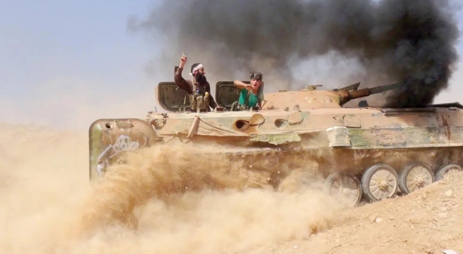 عناصر من قوات جيش الفتح المعارض لنظام الاسد على متن دبابة خلال معركة فك الحصار عن حلب في منطقة العامرية أمس (غيتي)