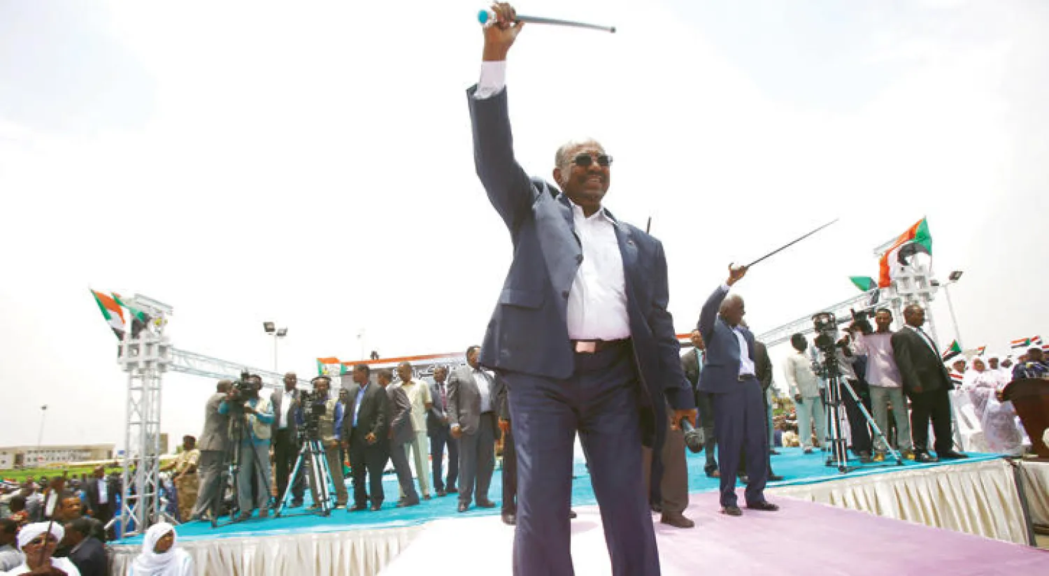 الرئيس السوداني عمر البشير يحيي أنصاره لدى وصوله إلى الخرطوم بعد مشاركته في منتدى أديس أبابا (أ.ف.ب)
