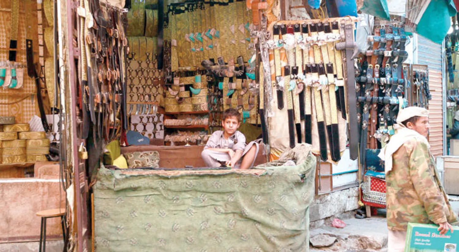 طفل يمني يجلس في متجر شعبي بوسط المدنية القديمة في العاصمة صنعاء (أ.ف.ب)