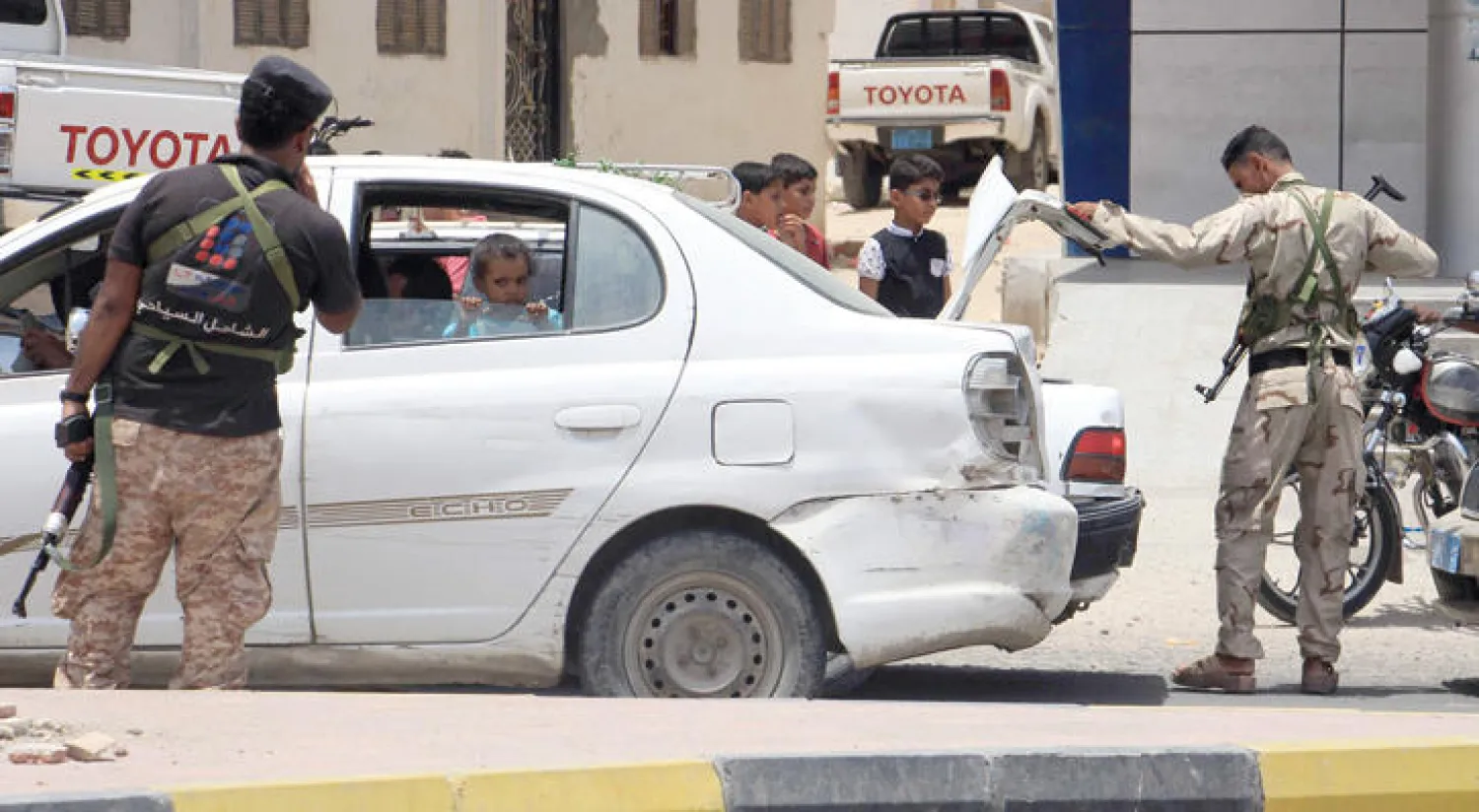 عناصر الأمن يتأكدون من سيارة مارة عبر نقطة تفتيش في حضرموت (أ.ف.ب)