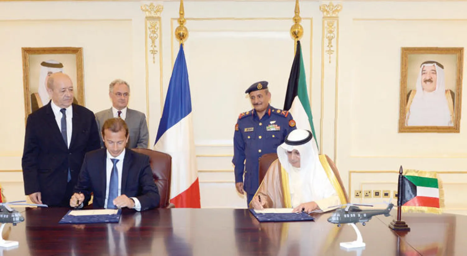 نائب رئيس مجلس الوزراء وزير الدفاع الكويتي  الشيخ خالد الجراح الصباح ووزير الدفاع الفرنسي جان إيف لودريان خلال توقيع العقد (أ ف ب)