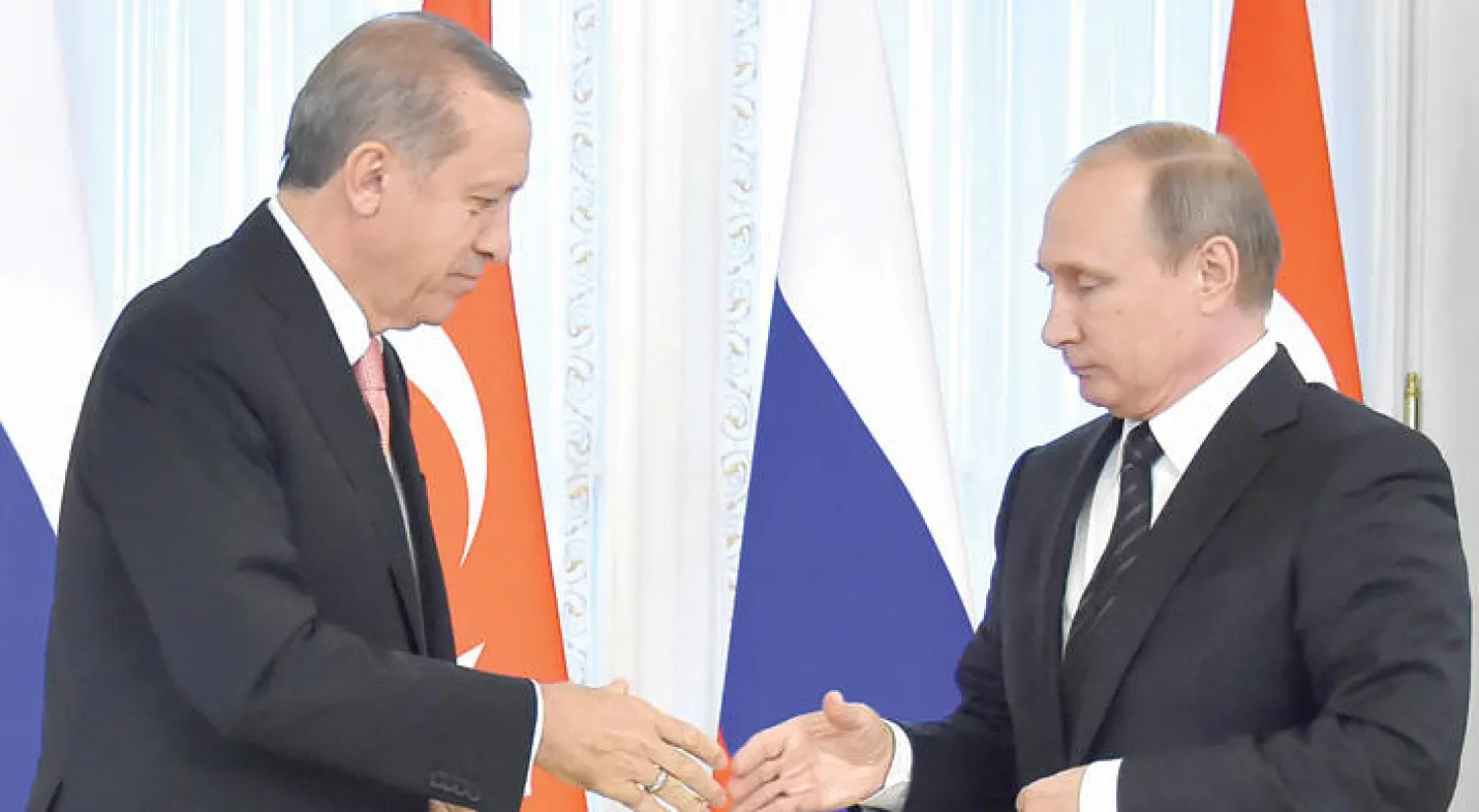 الرئيس الروسي فلاديمير بوتين مصافحًا نظيره التركي رجب طيب إردوغان لدى لقائهما في سان بطرسبرغ أمس، لأول مرة منذ إسقاط أنقرة مقاتلة روسية في نوفمبر (تشرين الثاني) الماضي. وبينما تعهد الزعيمان بإعادة العلاقات بين بلديهما إلى سابق عهدها، أفادت موسكو بأن الطرفين ملتزمان بإيجاد حل سلمي للأزمة السورية (أ.ف.ب)