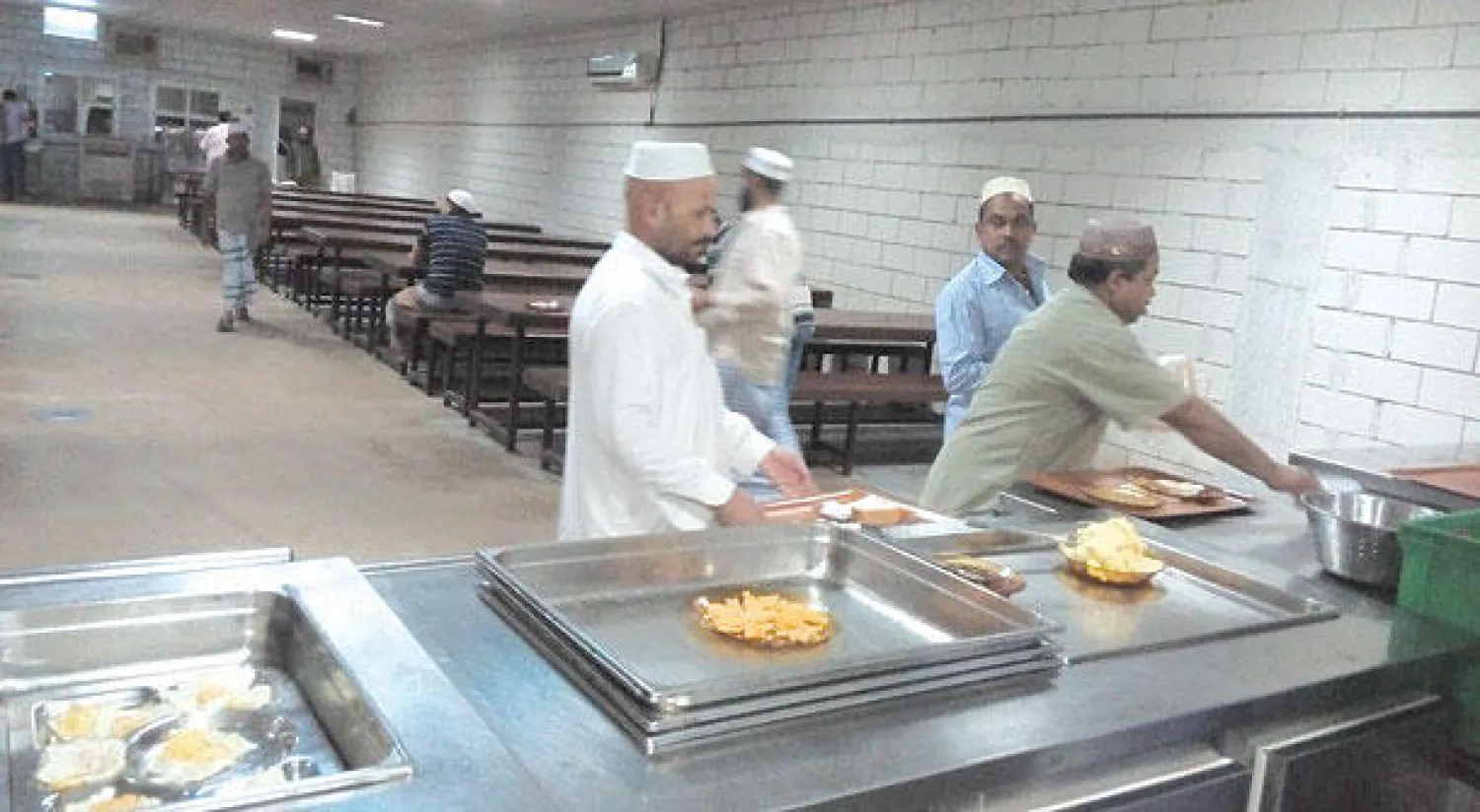 بعض العمالة المتضررة أثناء حصولهم على الإعاشة التي تقدمها وزارة العمل عبر مراكزها في الرياض وجدة  ({الشرق الأوسط})