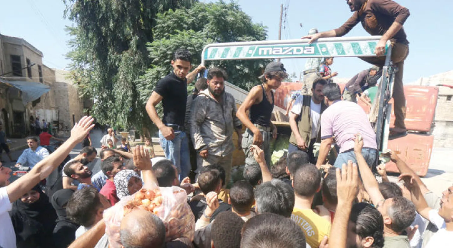 سكان الأحياء الشرقية في حلب تجمعوا أمس لشراء مواد غذائية دخلت عبر تجار في المنطقة قبل يوم (رويترز)