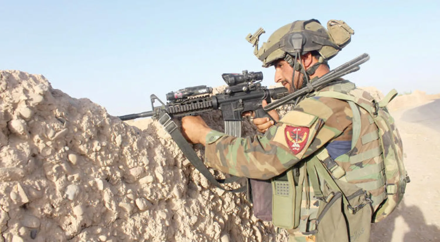 جندي أفغاني في موقع متقدم بولاية هلمند يتصدى لهجمات عناصر «طالبان» أمس (أ.ف.ب)