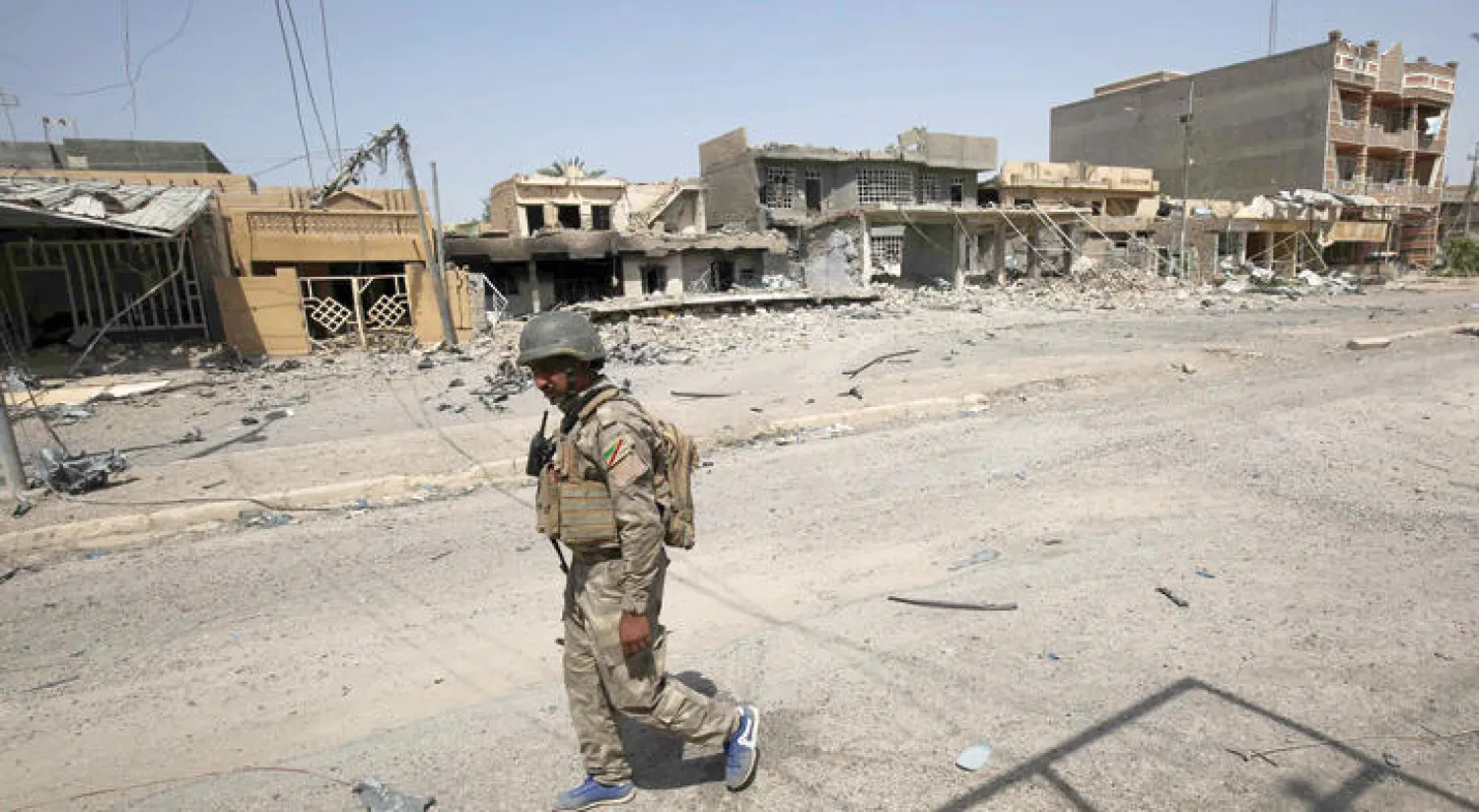 جندي عراقي يسير في أحد شوارع الفلوجة بعد استعادتها من {داعش} في 30 يونيو الماضي (ا.ف.ب)