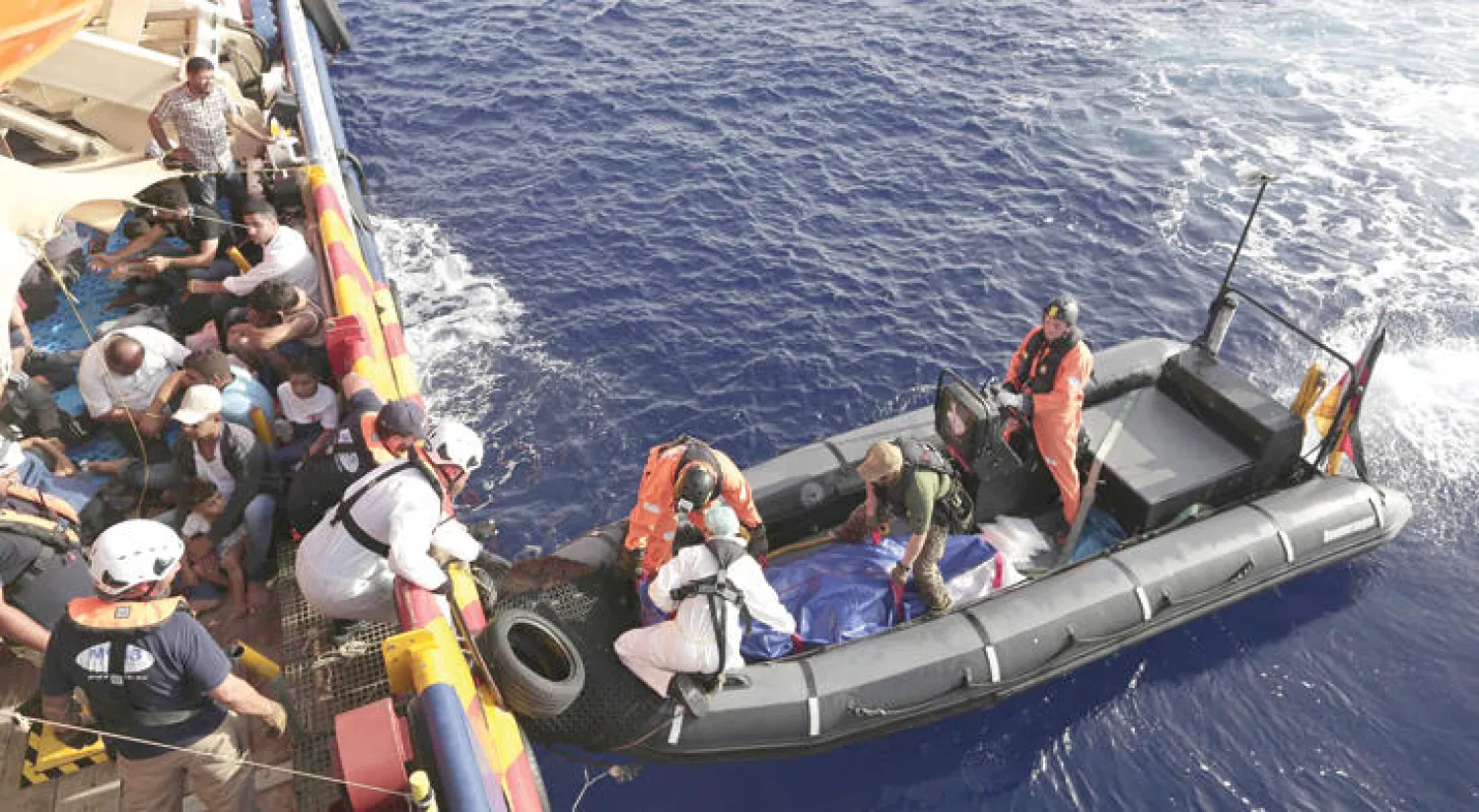 عناصر من {الصليب الأحمر} الإيطالي ينتشلون أجساد أمرأة ورجل وطفلين طافية على المياه بين مالطا وليبيا أول من أمس (إ.ب.أ)