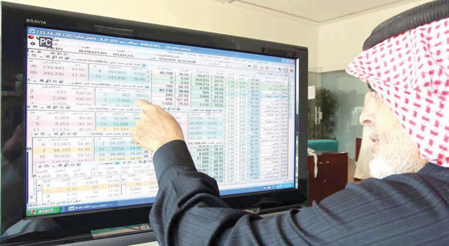 مستثمر يتابع أسعار الأسهم السعودية على شاشة تداول