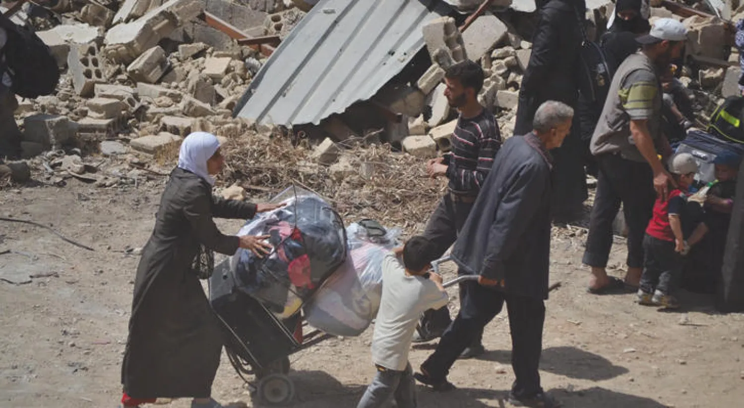 إحدى عائلات داريا المنكوبة، بكبارها وصغارها، حملت حوائجها وبدأت رحلة التهجير (إ.ب.أ)