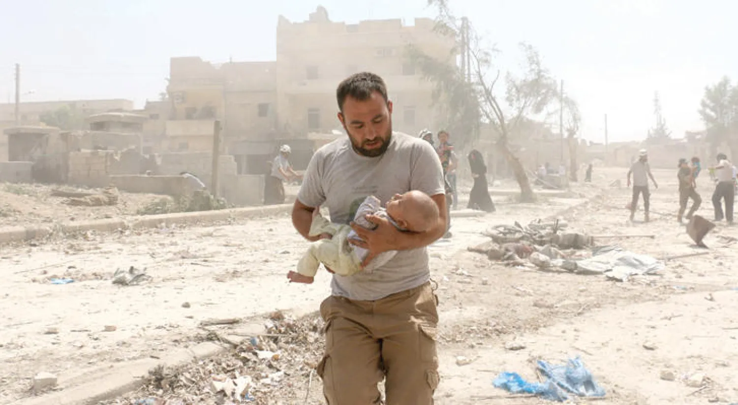 سوري يحمل رضيعا في حي المعادي بحلب بعد قصفه بالبراميل المتفجرة من قبل طائرات النظام أمس (أ.ف.ب)