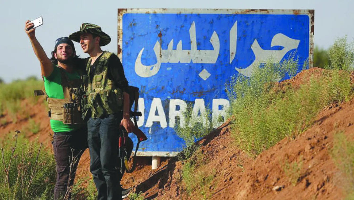 مقاتلان في الجيش السوري الحر يلتقطان صورة سيلفي قرب قرية العمارنة بريف جرابلس أمس بعد أن استعاد «الحر» السيطرة عليها من قوات سوريا الديمقراطية (غيتي)