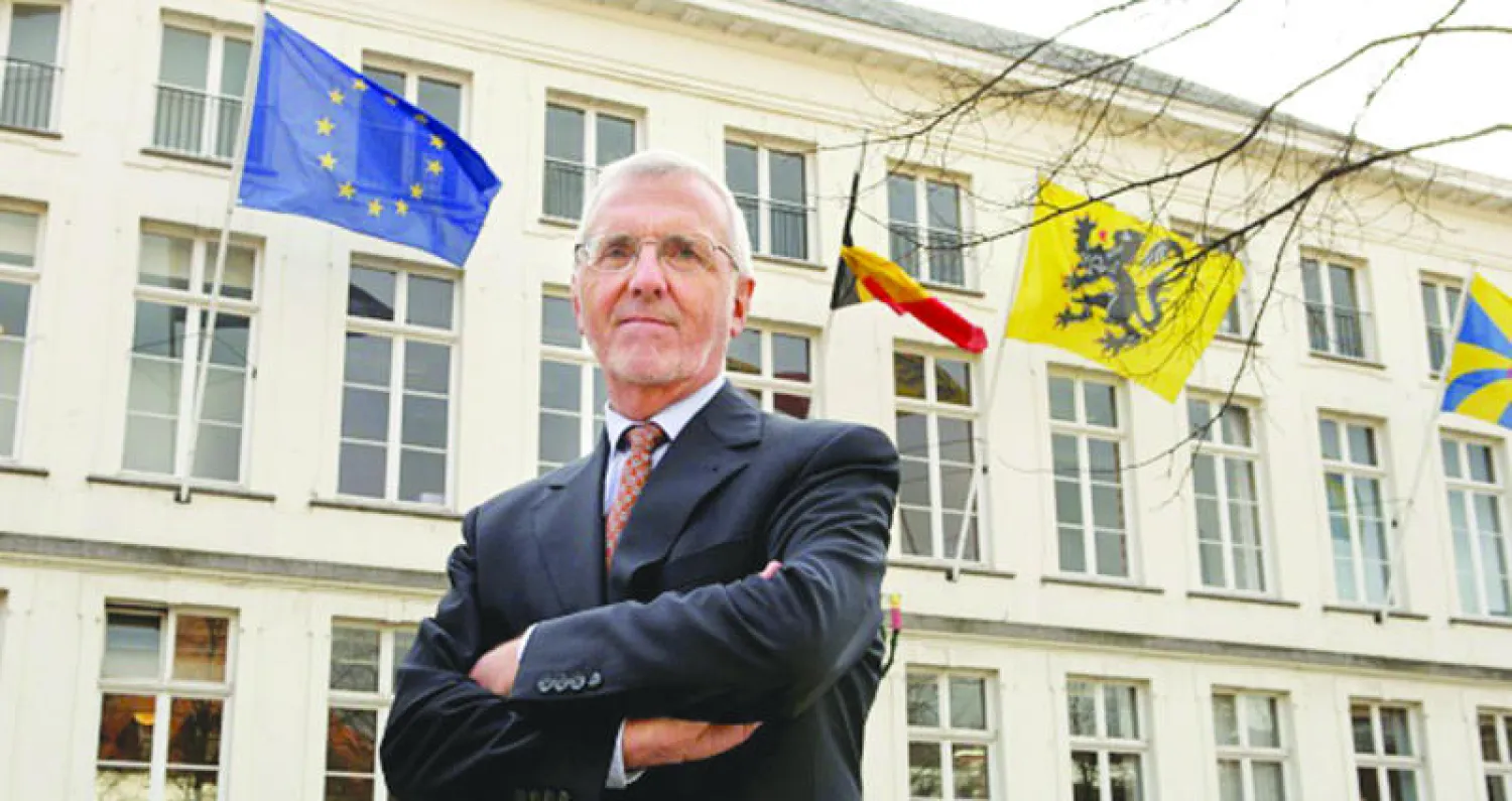 عميد الكلية السابق بول ديميريه أمام حرمها في بروج البلجيكية (غيتي)