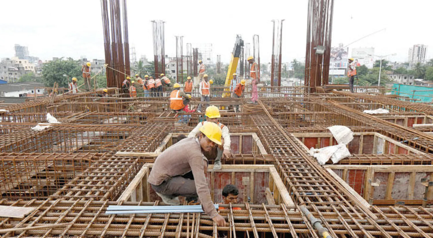 عمال داخل إحدى الورش البناء المخصصة لبناء محطة للسكك الحديدية في كالكوتا (رويترز)