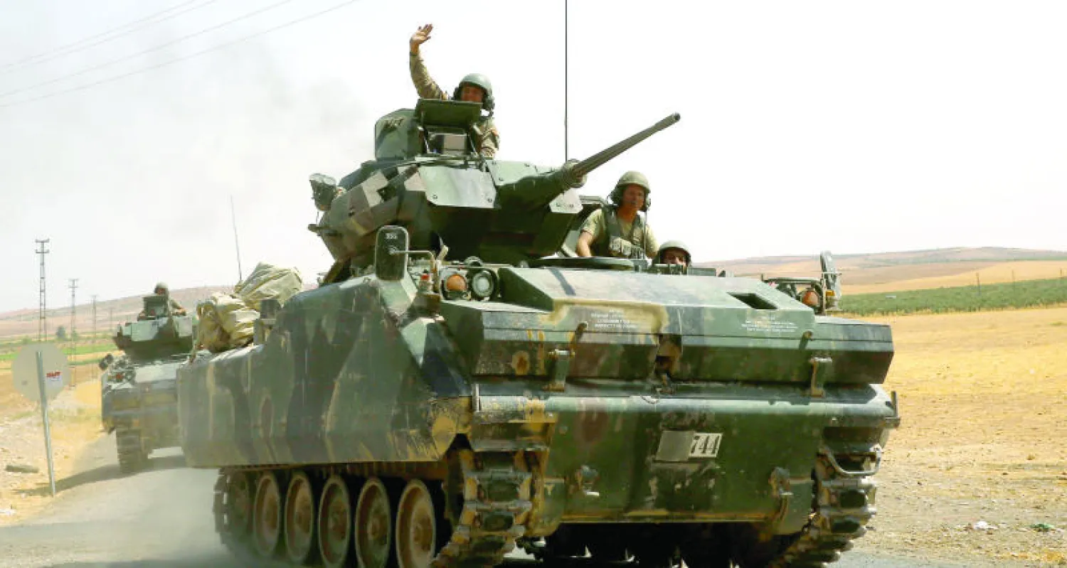مدرعتان تركيتان ضمن رتل من العربات المدرعة تقوم بدورية بالقرب من محافظة غازي عنتاب  جنوب شرق تركيا على الحدود مع سوريا أمس (رويترز)
