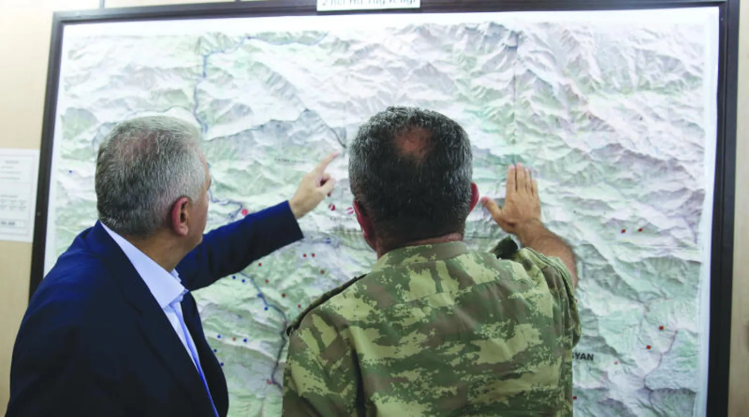 مسؤول أمني يطلع رئيس الوزراء التركي بن على يلدريم على خريطة للحدود العراقية ـــ التركية (أ.ب)