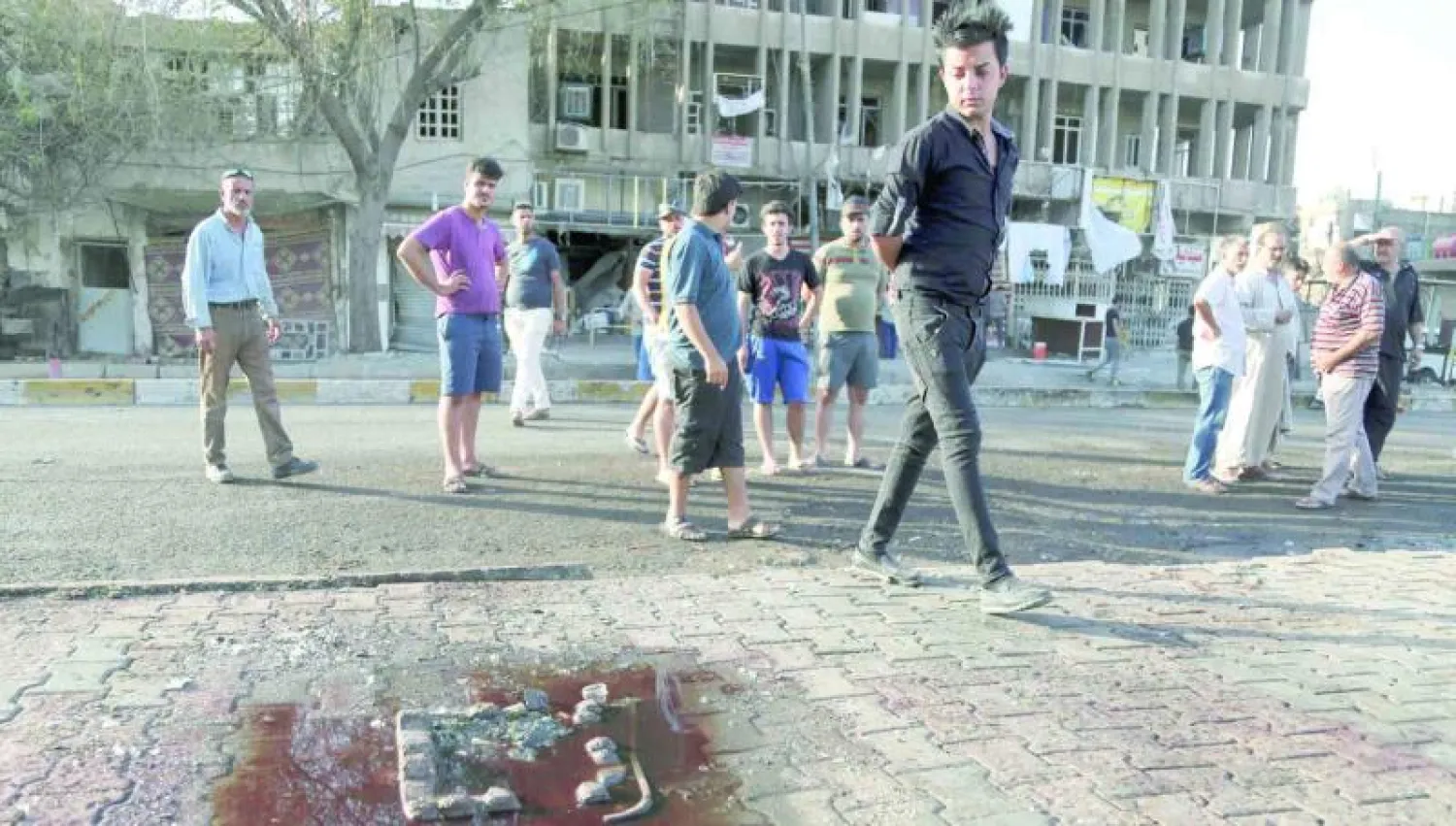 عراقيون يعاينون أمس موقع انفجار شهدته مساء أول من أمس منطقة الكرادة في بغداد (أ.ب)