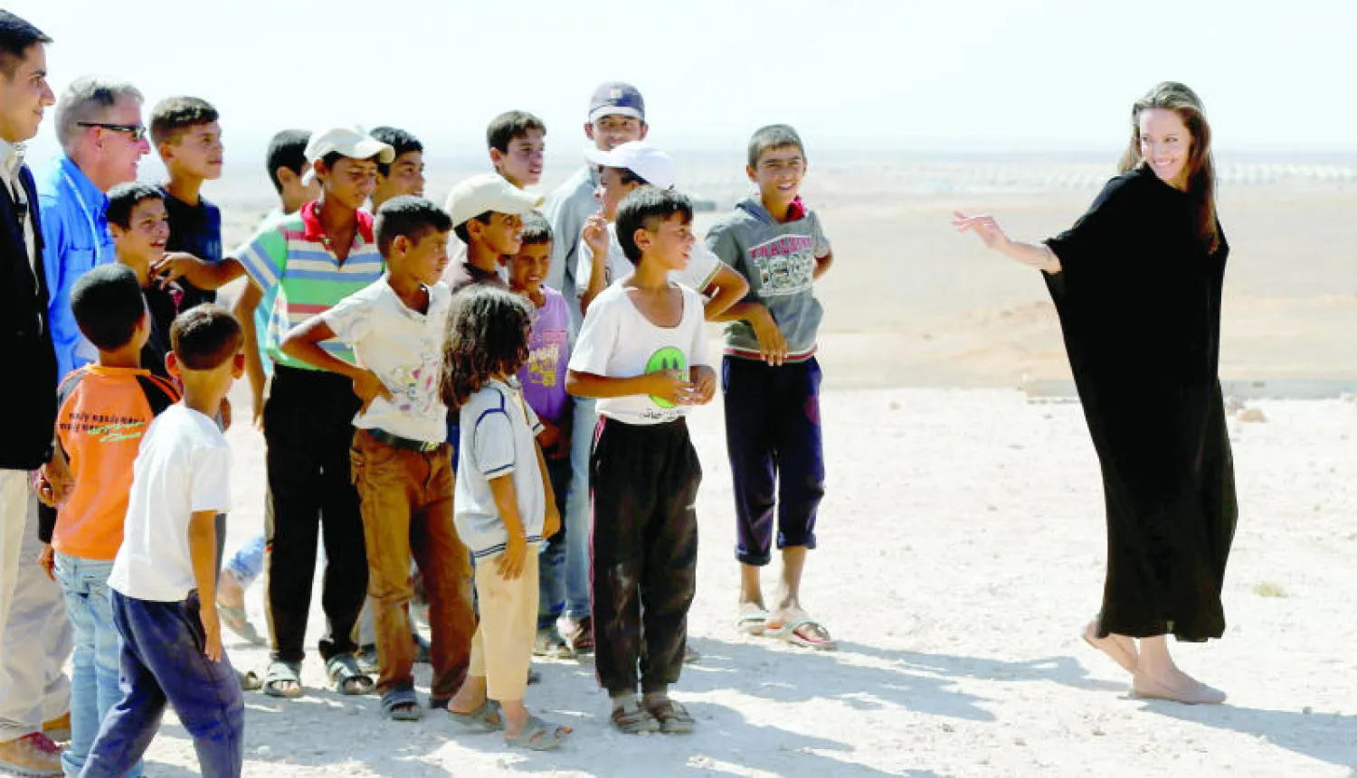 الممثلة الأميركية أنجلينا جولي في حديث باسم مع عدد من الأطفال السوريين اللاجئين في الأردن (رويترز)