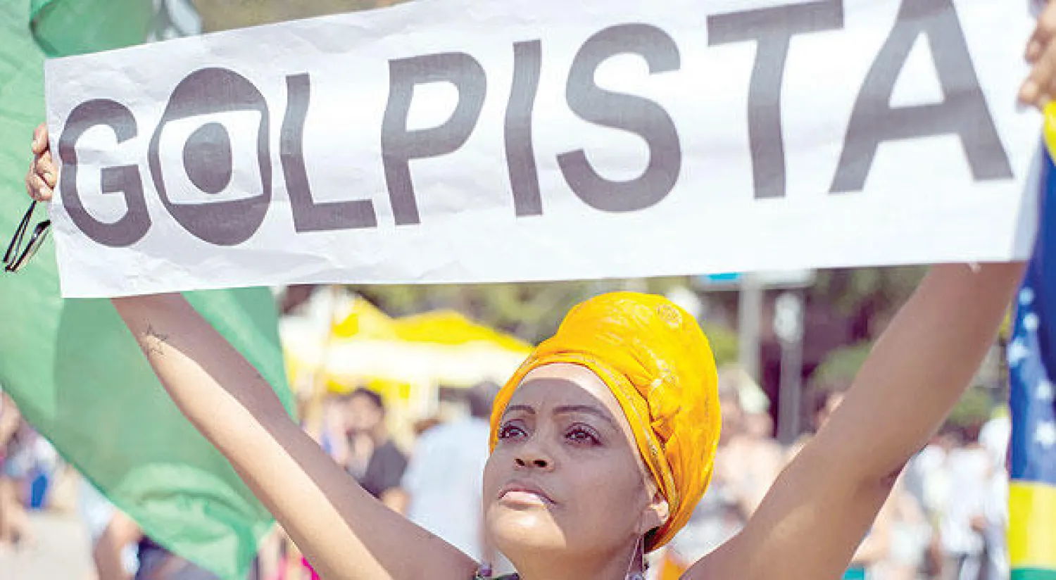 متظاهرة برازيلية ترفع لافتة مكتوبا عليها «انقلابي» في ريو دي جانيرو (رويترز)