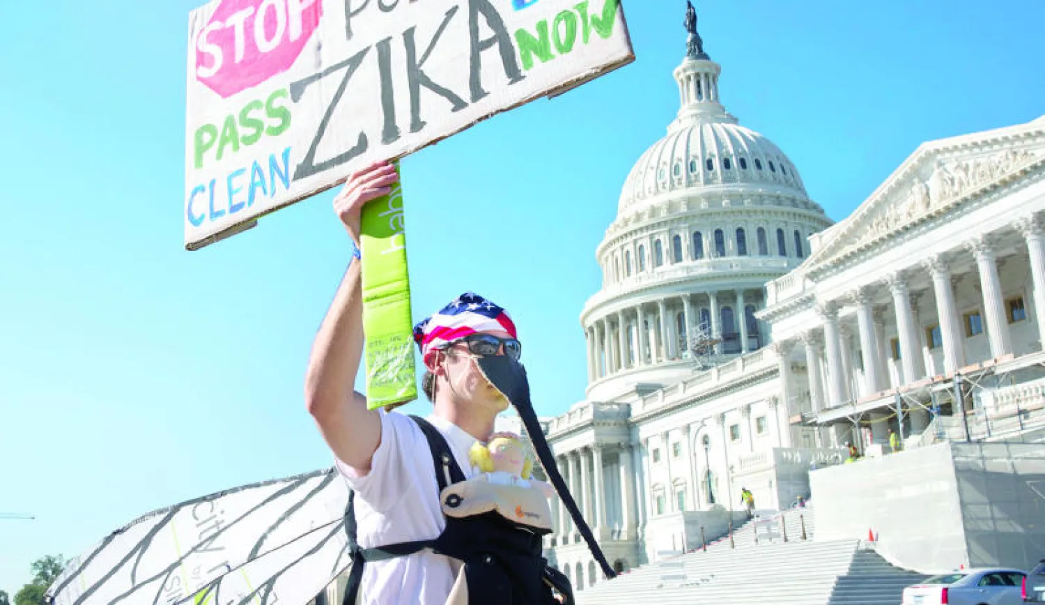 متظاهر (أب ينتظر قدوم مولوده) أمام الكونغرس يطالب بمزيد من الدعم المالي لصالح أبحاث حول فيروس «زيكا» وعلاقته بصغر حجم الرأس لدى المواليد (أ.ب)