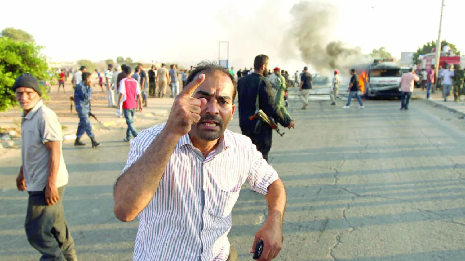 مواطن ليبي يفر من مكان انفجار سيارة خلال مظاهرة مؤيدة للمشير خليفة حفتر أول من أمس في بنغازي (أ.ف.ب)