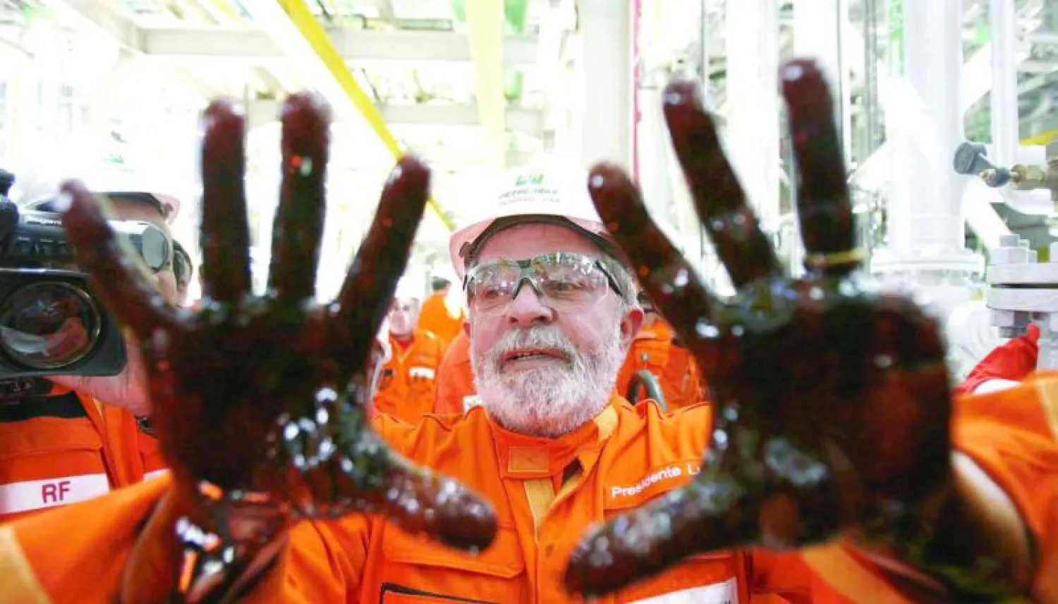 الرئيس لولا دا سيلفا يظهر ويداه مغطاتان بالزيت خلال افتتاح منصة مجموعة بتروبراس النفطية العملاقة  (إ.ب.أ)