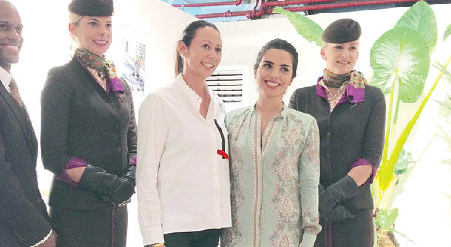 أمينة طاهر من شركة الاتحاد للطيران وكارولاين راش الرئيس التنفيذي لمنظمة الموضة البريطانية مع مضيفتين بزي «الاتحاد»