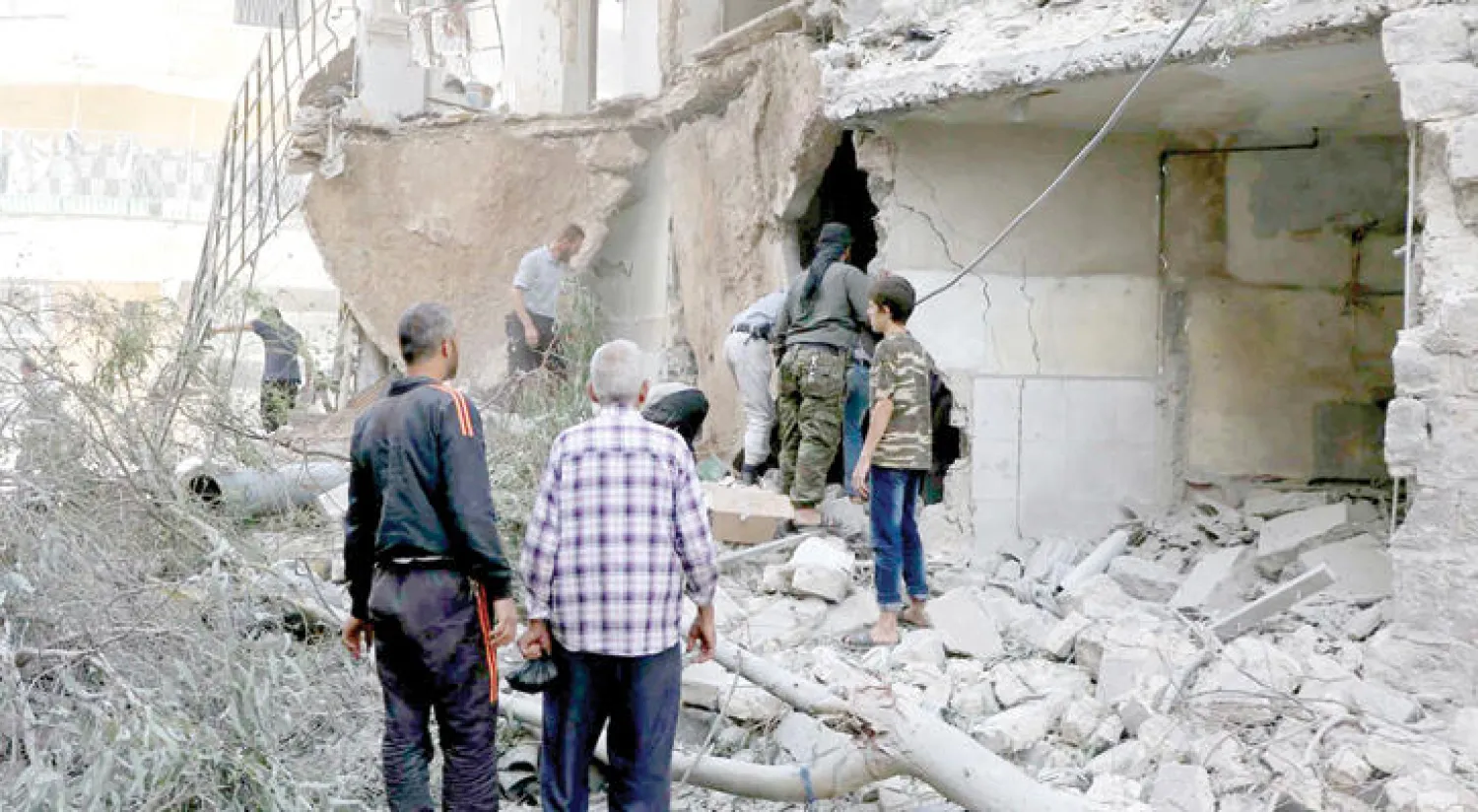 قوات الدفاع المدني ينقذون ضحايا قصف الطيران الروسي والأسدي على حي المشهد في حلب أول من أمس (إ.ب)